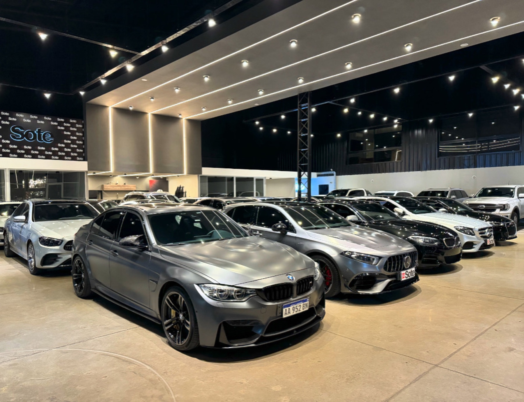 Showroom SOTE Automotores en Nordelta — interior con BMW M3, Mercedes AMG y autos premium